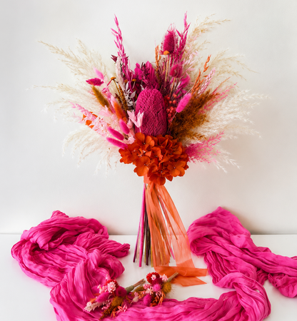Australian Native Hot Pink Banksia Bridesmaid Bouquet with preserved hydrangea, pampas grass and dried flowers in magenta, pink and burnt orange tones for colourful boho weddings.