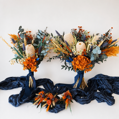 Australian native dried wedding flower collection featuring bridal bouquet, bridesmaid bouquet, boutonnieres and accessories in burnt orange, navy blue, banksia and preserved eucalyptus.