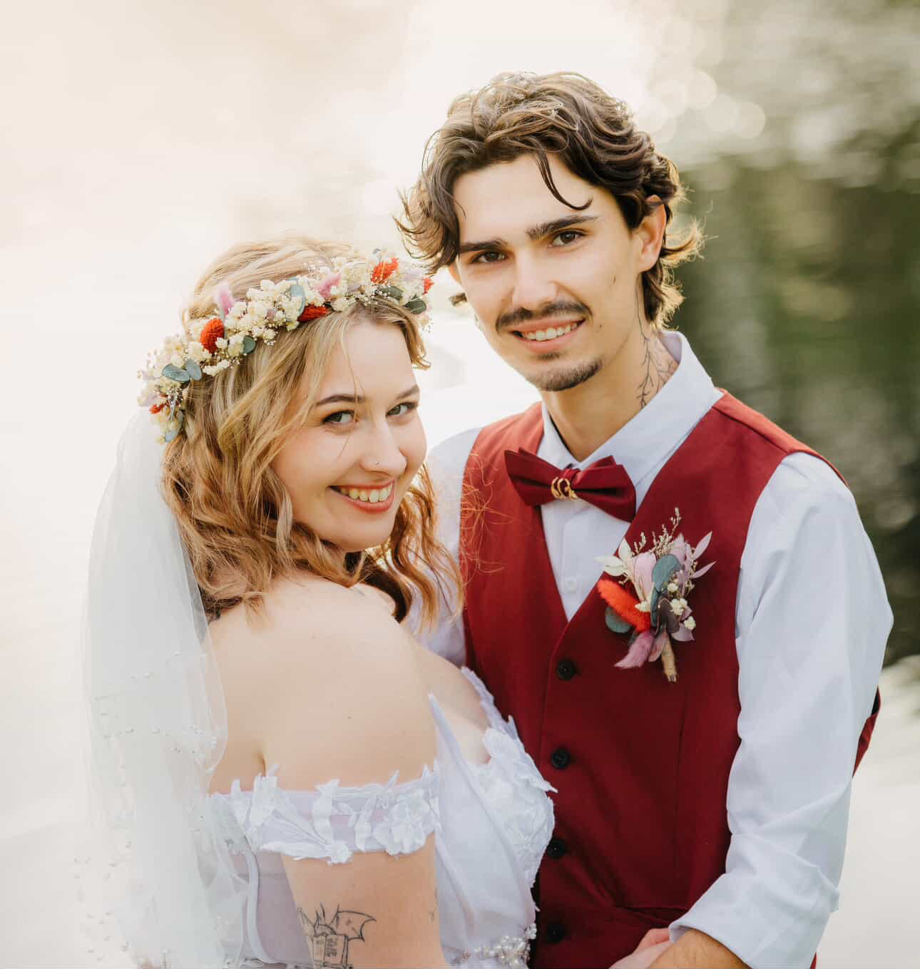 Bride and groom during an outdoor Australian wedding, with the bride wearing a boho dried flower crown and holding a pastel dried flower bouquet near the water.