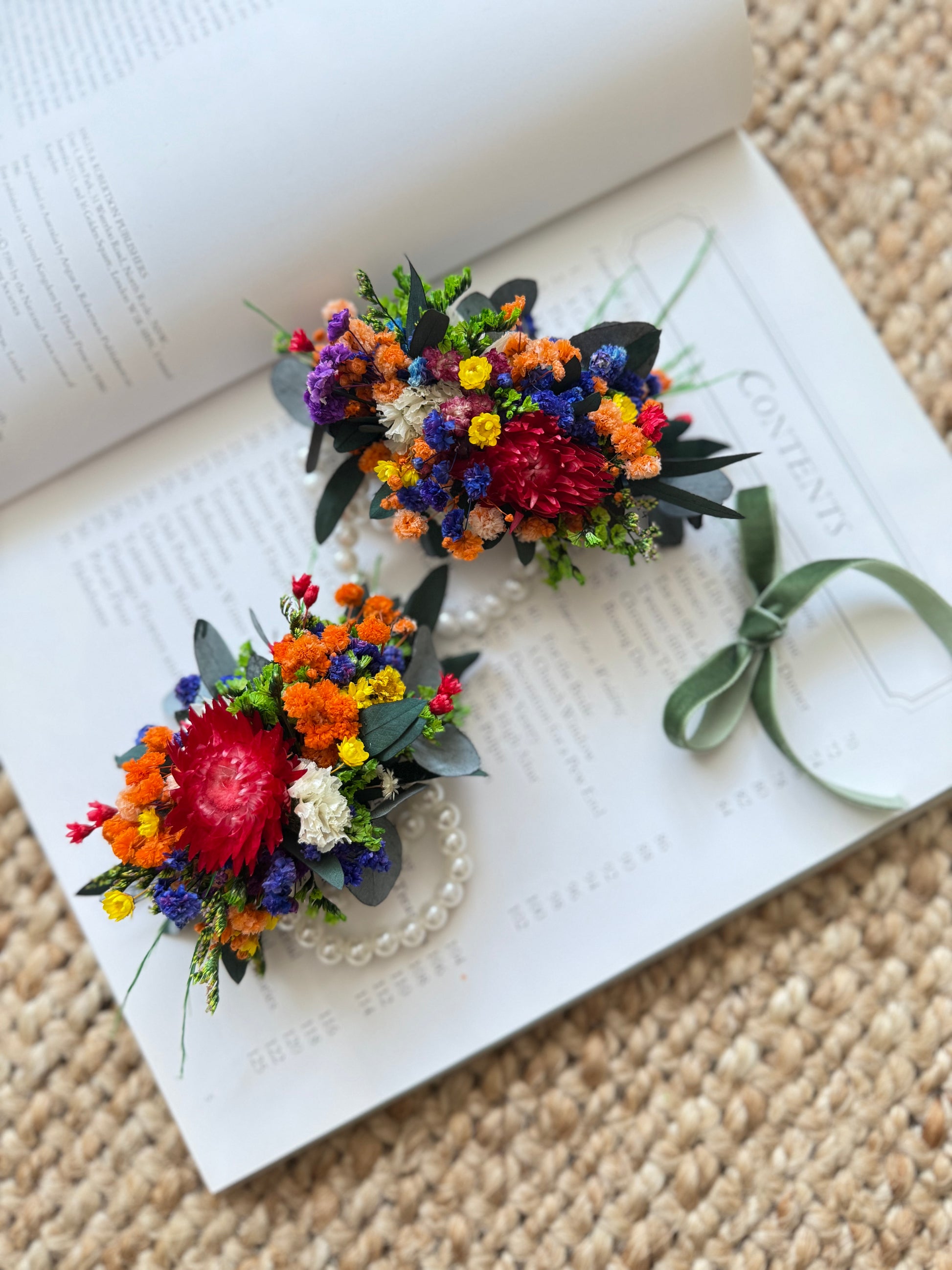 Dried flower wrist corsage in Australian wildflower colors with elastic pearl band and green ribbon tie