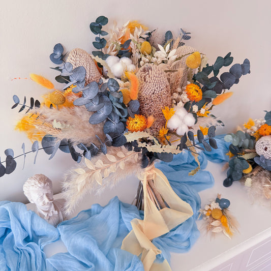 Boho dried flower wedding bouquet with pampas grass, blue eucalyptus and yellow accents, rustic bridal arrangement