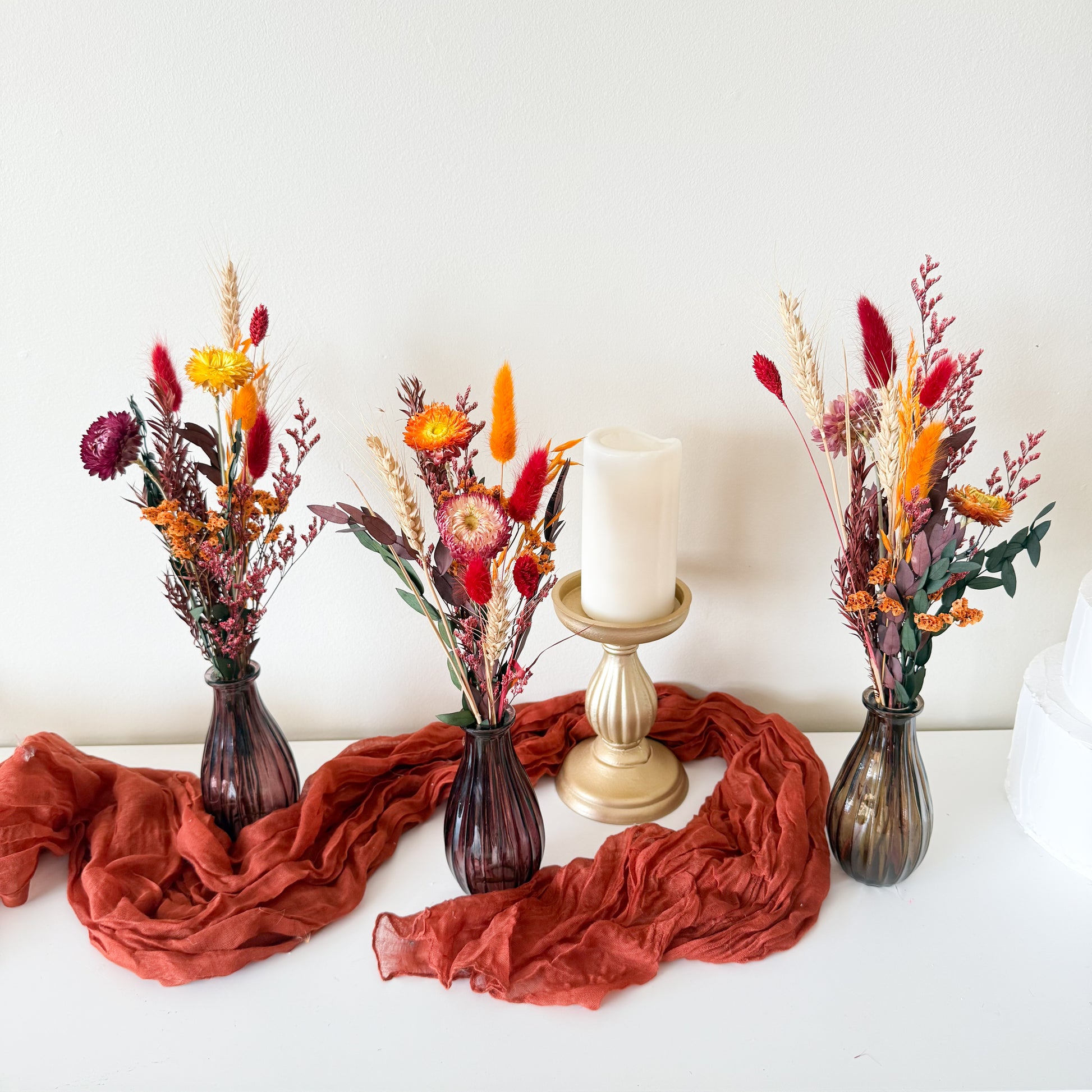 Australian handmade boho vase decor with mixed dried flowers in warm autumn shades of orange, red, and gold.