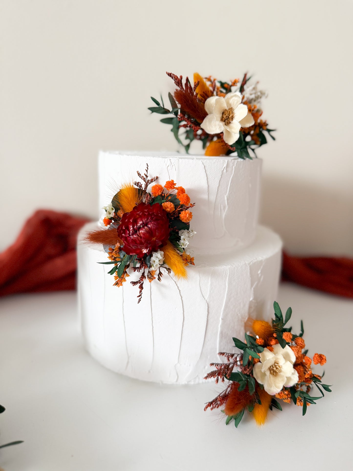 Rustic autumn wedding cake decorated with terracotta and ivory dried flowers