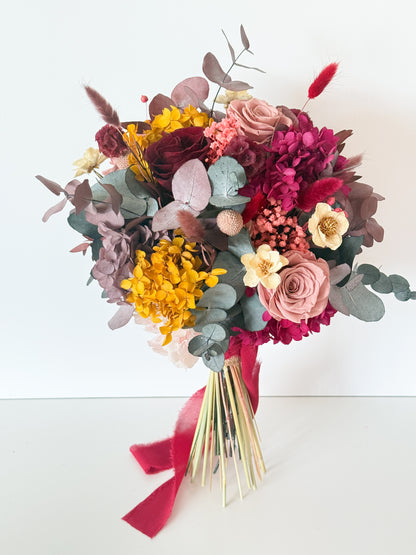 Autumn wedding bouquet featuring preserved flowers in golden yellow, dusty rose, and burgundy tones, ideal for boho and rustic brides
