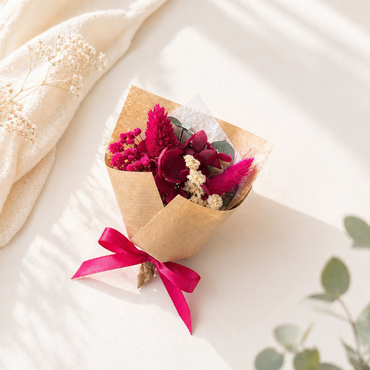 Mini berry pink dried flower bouquet wrapped in kraft paper with satin ribbon, ideal for bridesmaid proposal or romantic gift
