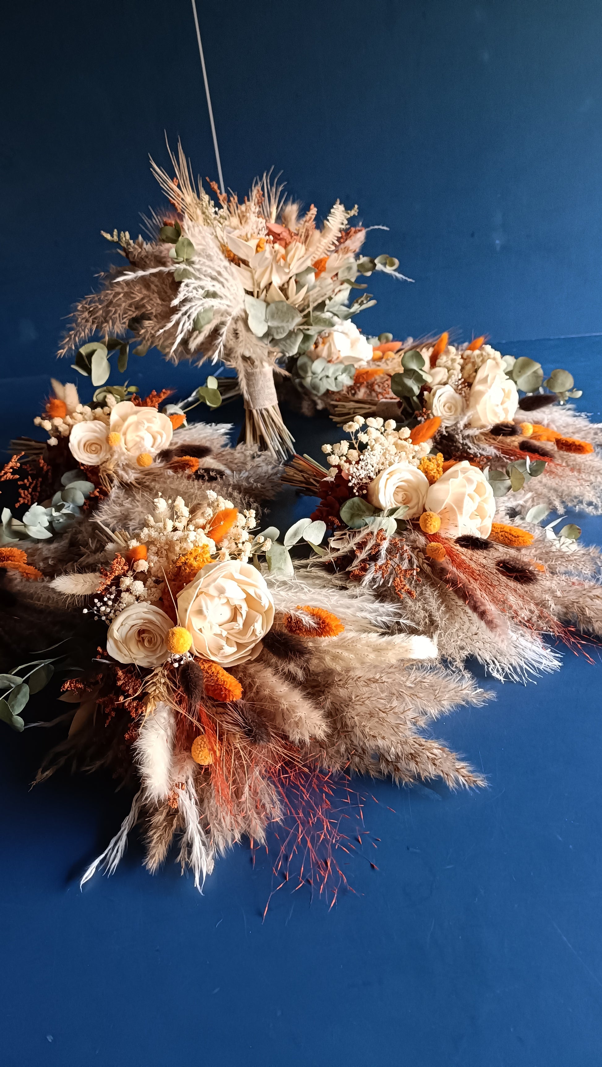 Unique bridal bouquet crafted from preserved flowers, featuring a rich palette of oranges, greens, and whites. A long-lasting alternative to fresh flowers, tailored for boho brides.