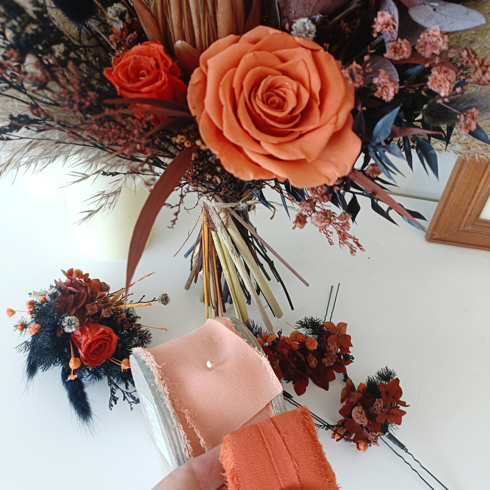 Burnt orange and navy dried flower boutonniere with preserved hydrangea and natural textures