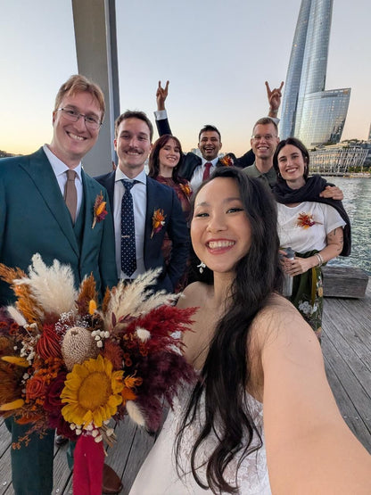 Bride with boho orange and burgundy bouquet
