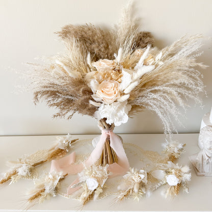 Bouquet of dried flowers and pampas grass on a white surface with a neutral background