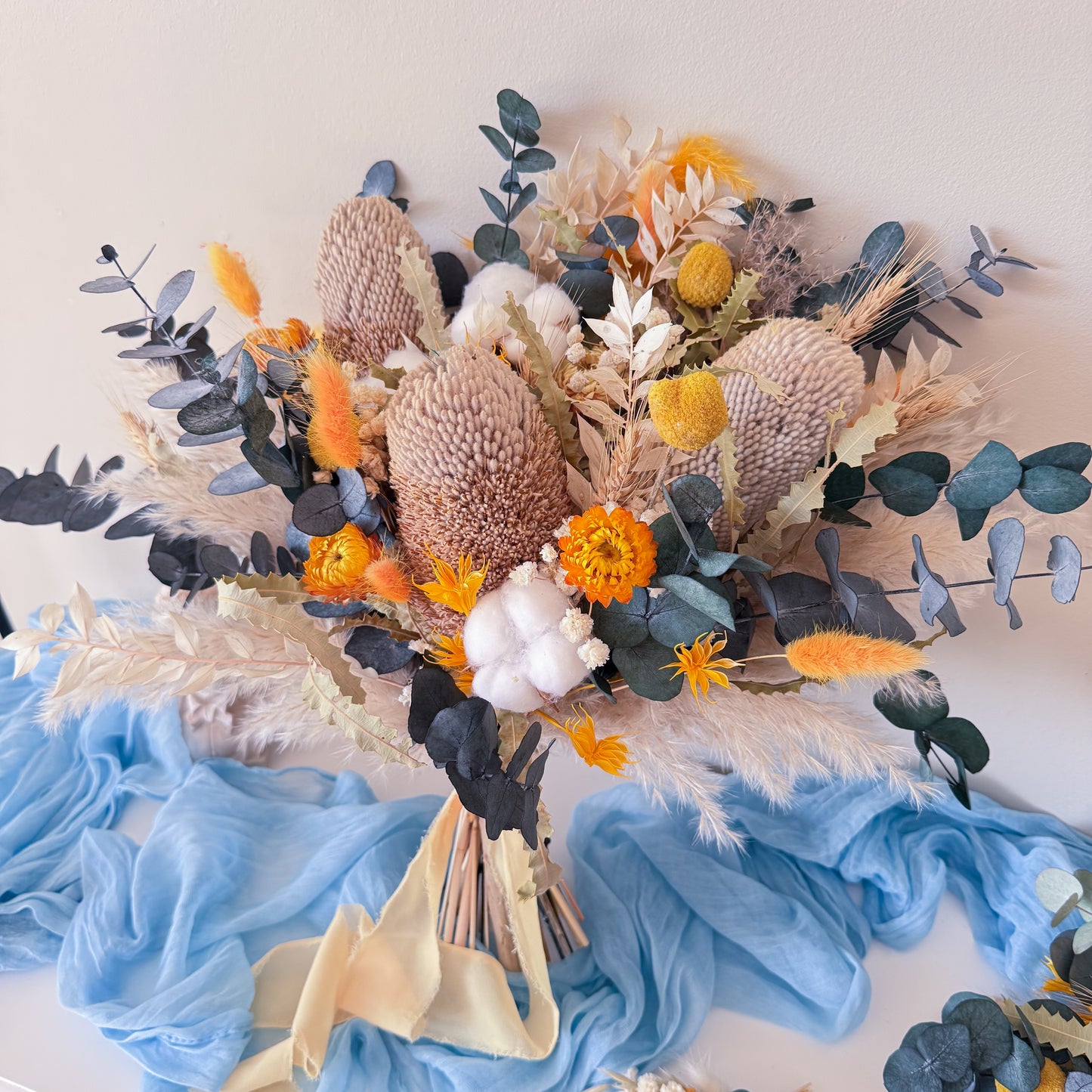 Boho wedding dried flower bouquet with blue eucalyptus, neutral tones and yellow accents
