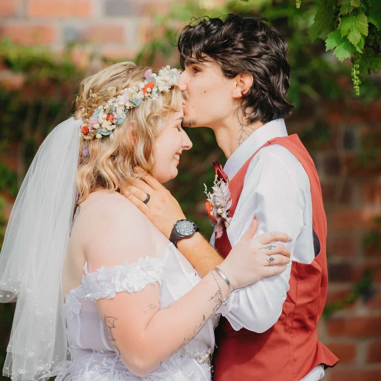 Romantic wedding moment with the bride wearing a dried flower crown and the groom embracing her during an outdoor Australian celebration