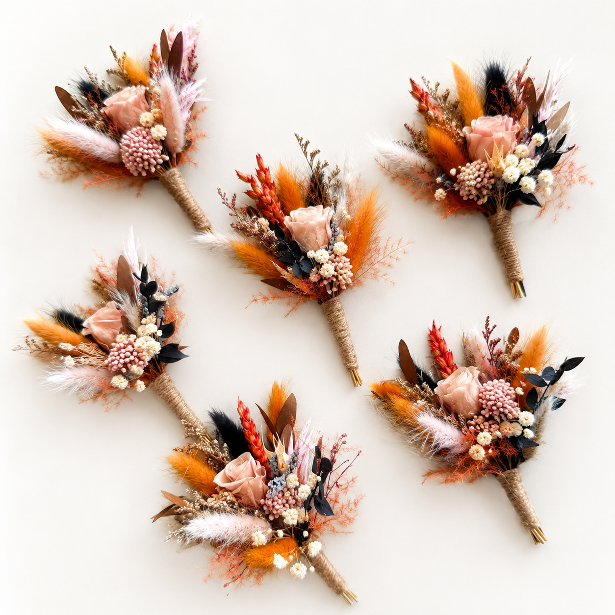 Matching dried flower boutonnieres in terracotta and blush tones for boho wedding styling