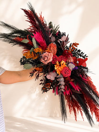 Burgundy and rust dried flower wedding arch arrangement with preserved roses, dark foliage and native flowers