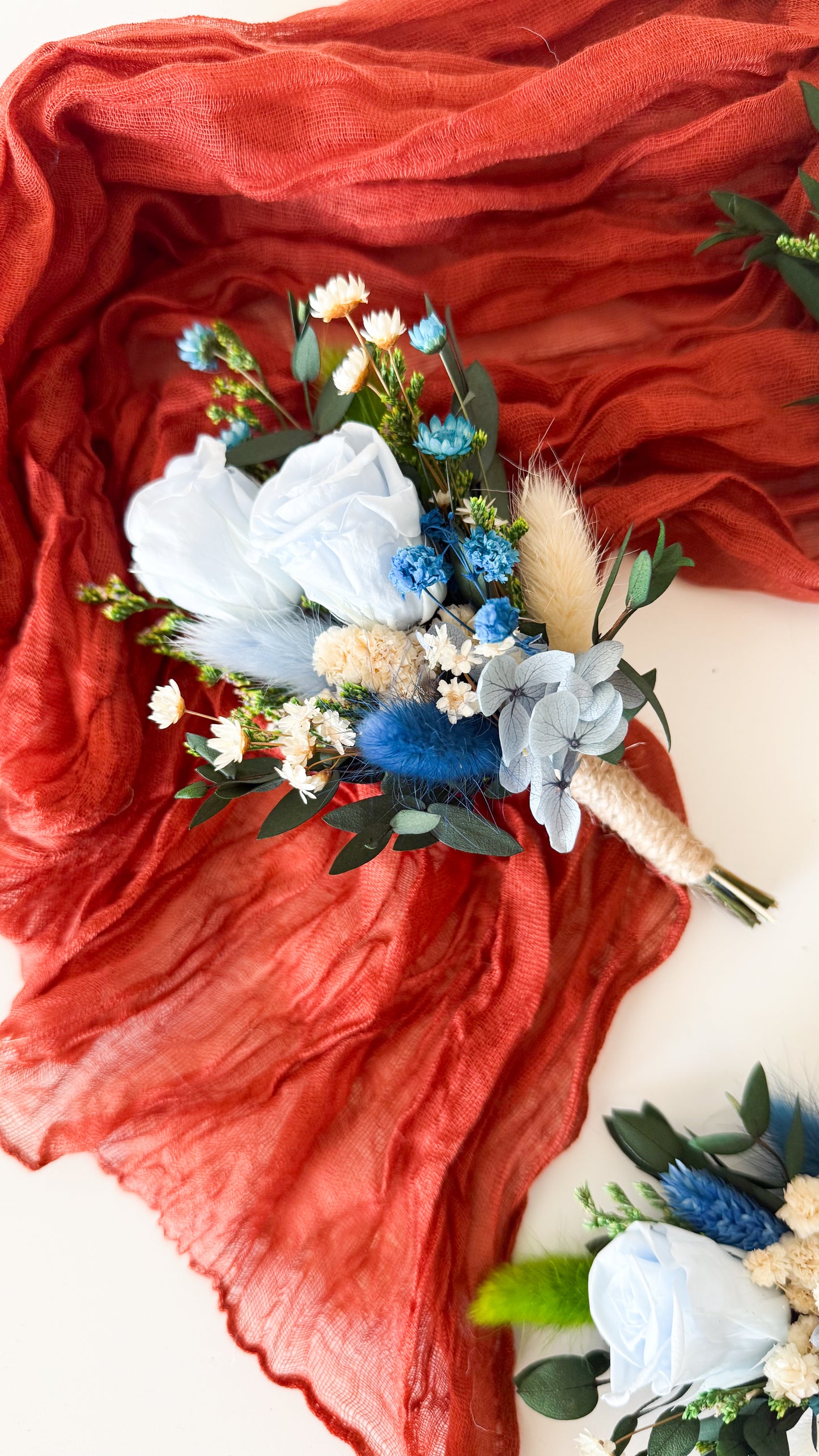 Rustic boutonniere with dusty blue flower, eucalyptus leaves, and dried details — handmade accessory for groom, groomsmen, or fathers.