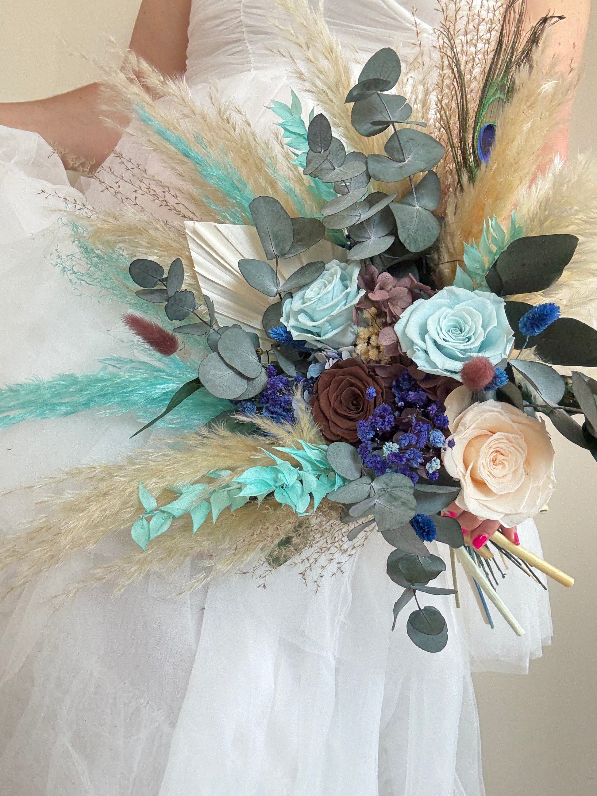 Bride holding teal and navy preserved flower bouquet — lightweight, one-sided design.