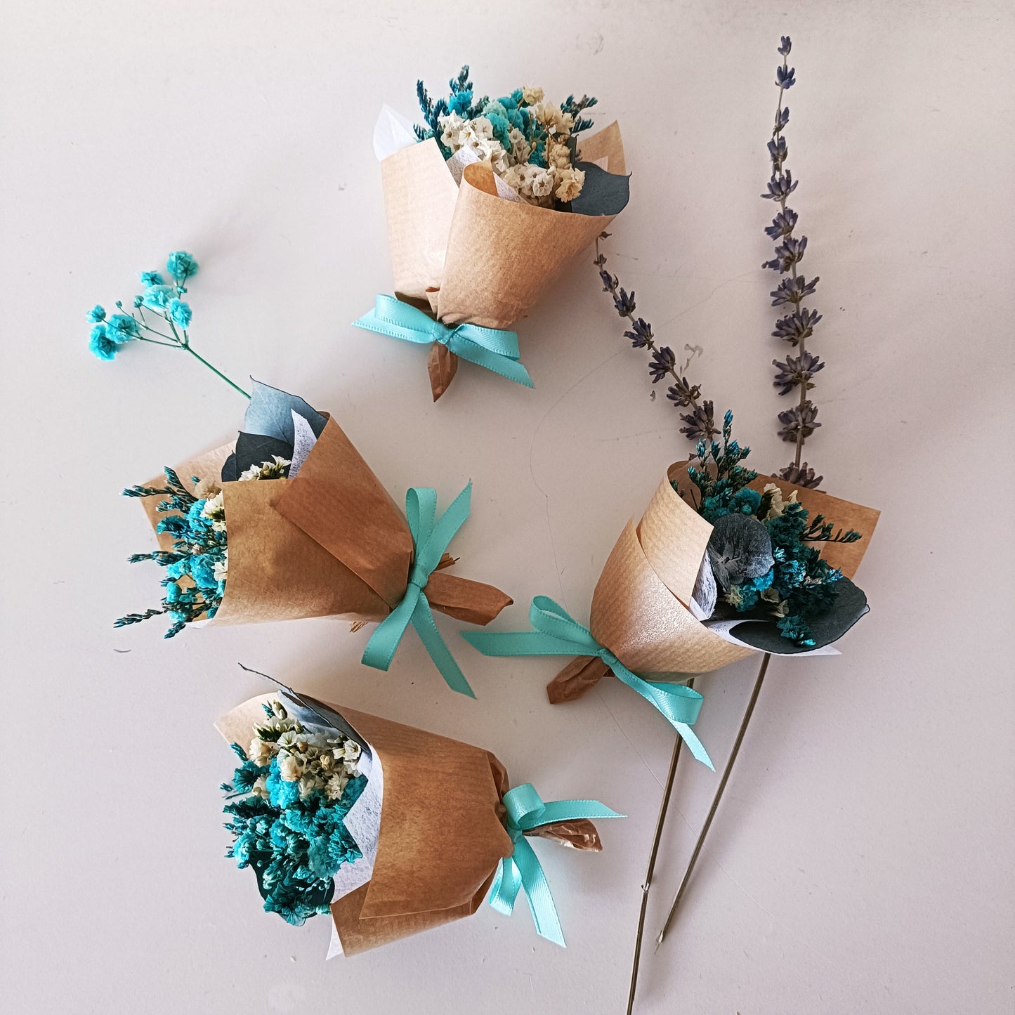 Collection of mini teal bouquets ready for packaging, ideal as sustainable wedding favours.
 