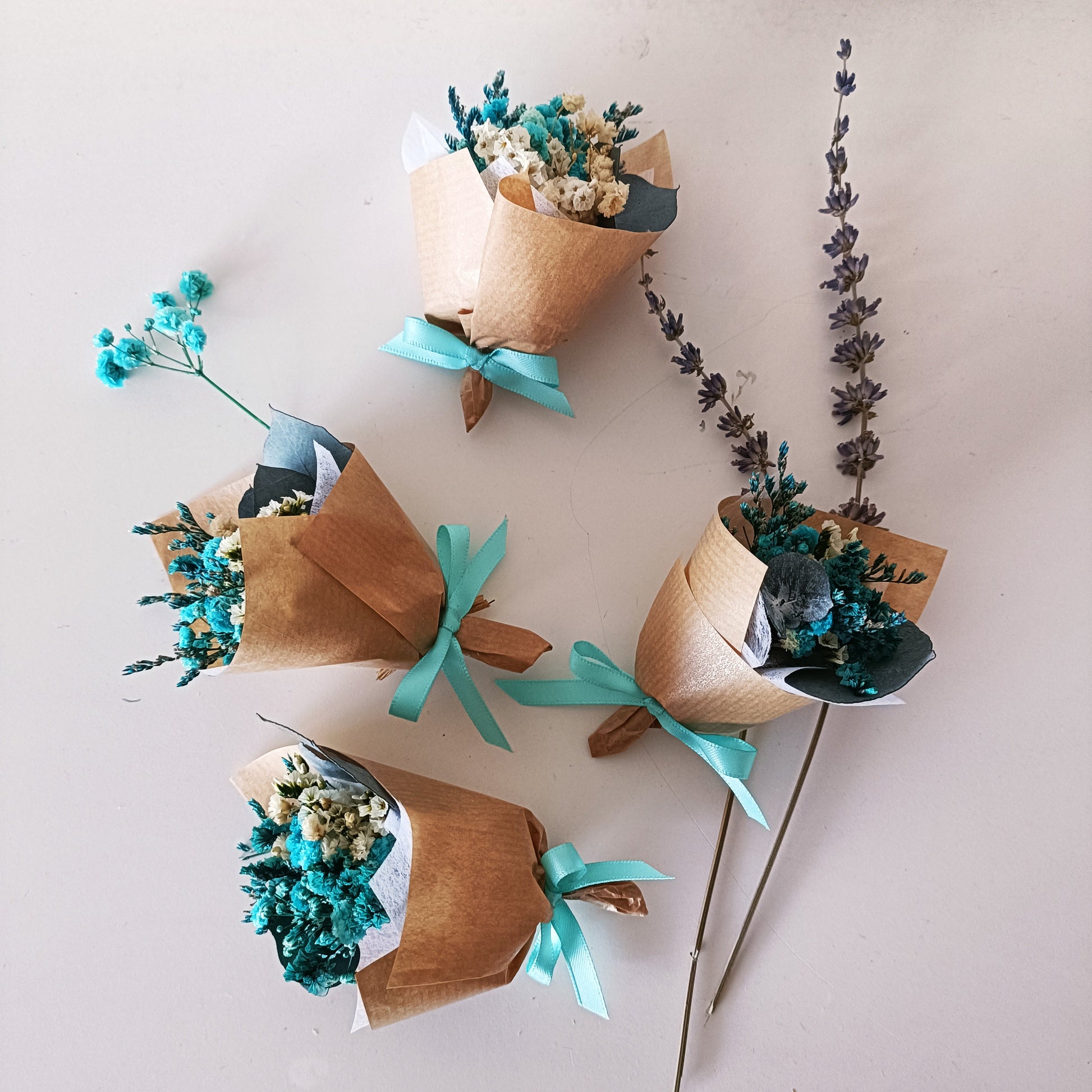 Collection of mini teal bouquets ready for packaging, ideal as sustainable wedding favours.
 
