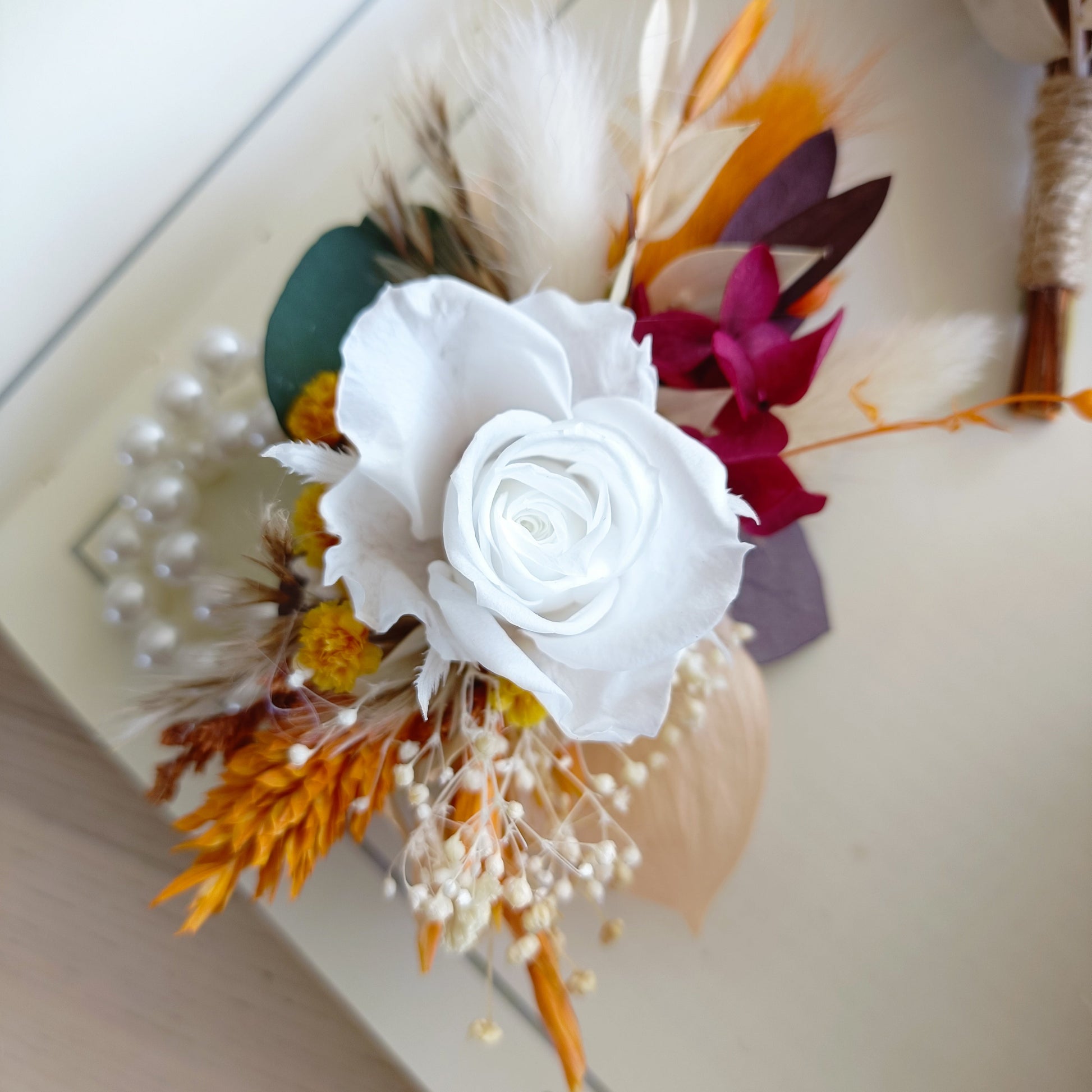 Neutral and burgundy dried wrist corsage on bride’s wrist for wedding