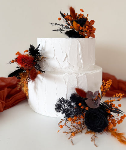 Elegant dried flower cake topper featuring black roses and burnt orange preserved accents