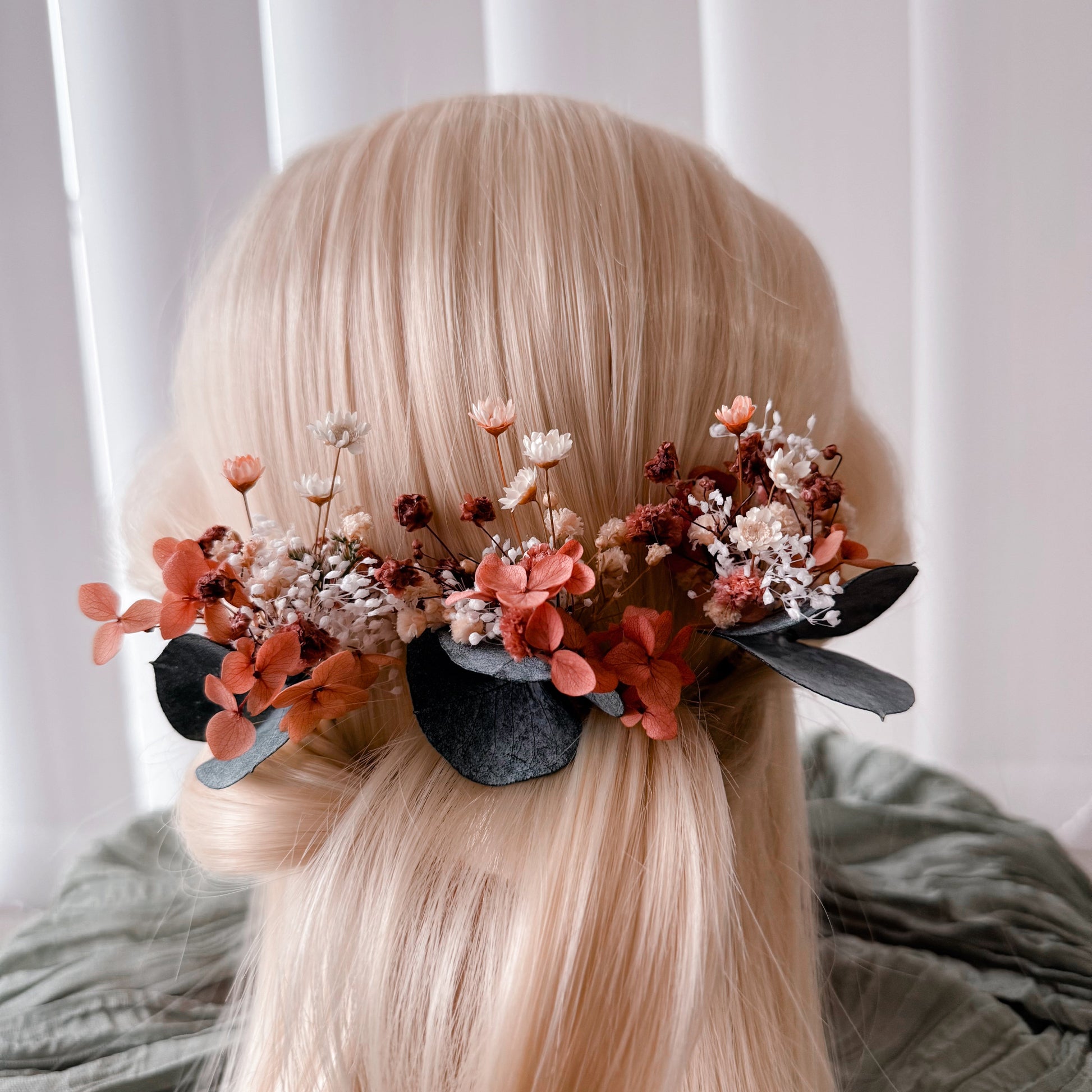 Side view of a burnt orange preserved flower bridal hair accessory with eucalyptus accents, suited for romantic and bohemian wedding hairstyles