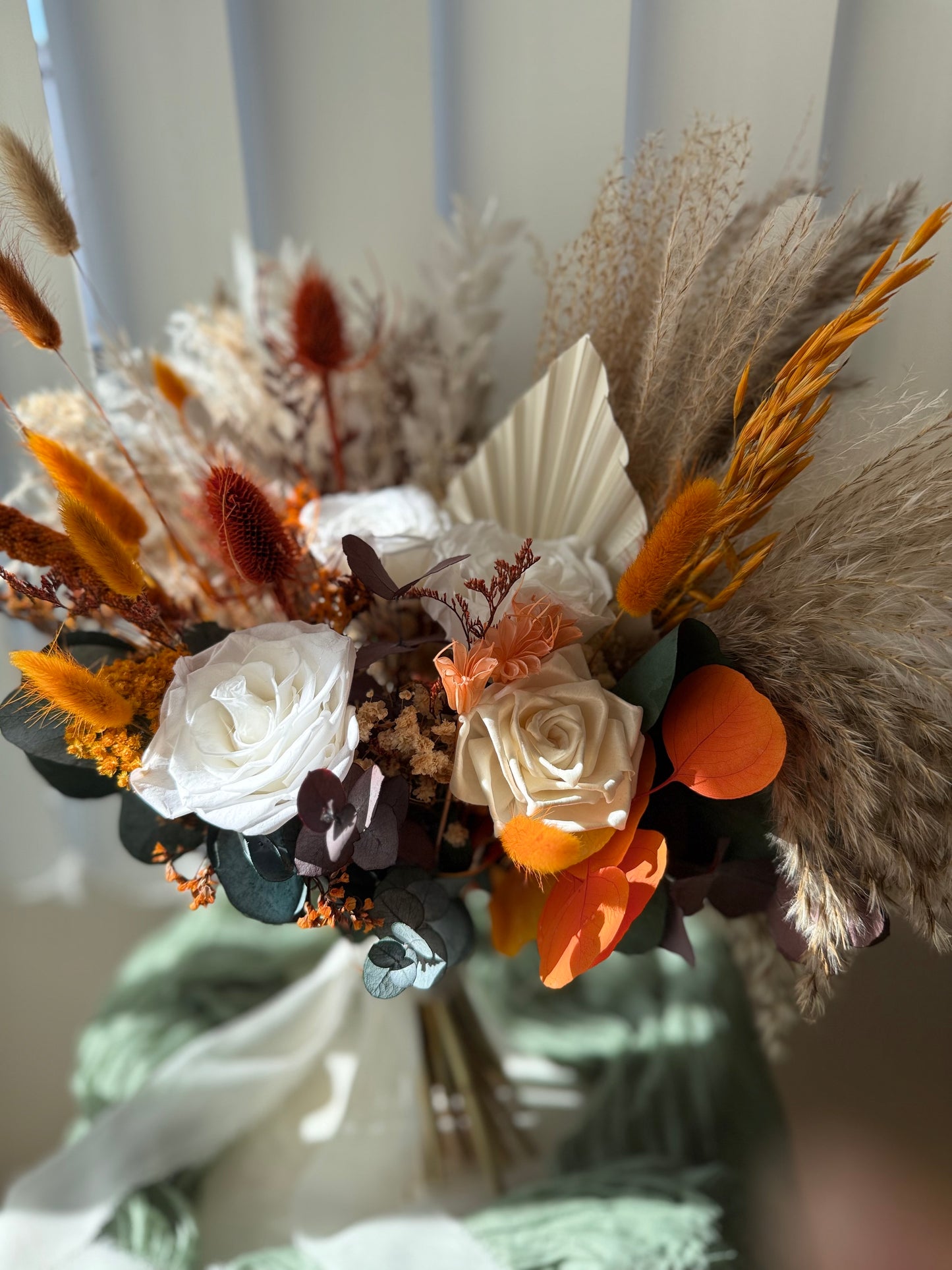 Burnt orange and cream dried flower bouquet with sola wood roses, pampas, and eucalyptus — perfect bohemian wedding flowers for brides.