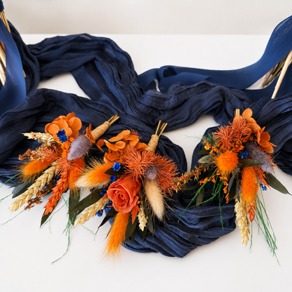 Set of handmade dried wedding boutonnieres in burnt orange and navy blue with preserved flowers, wheat and Australian native textures.