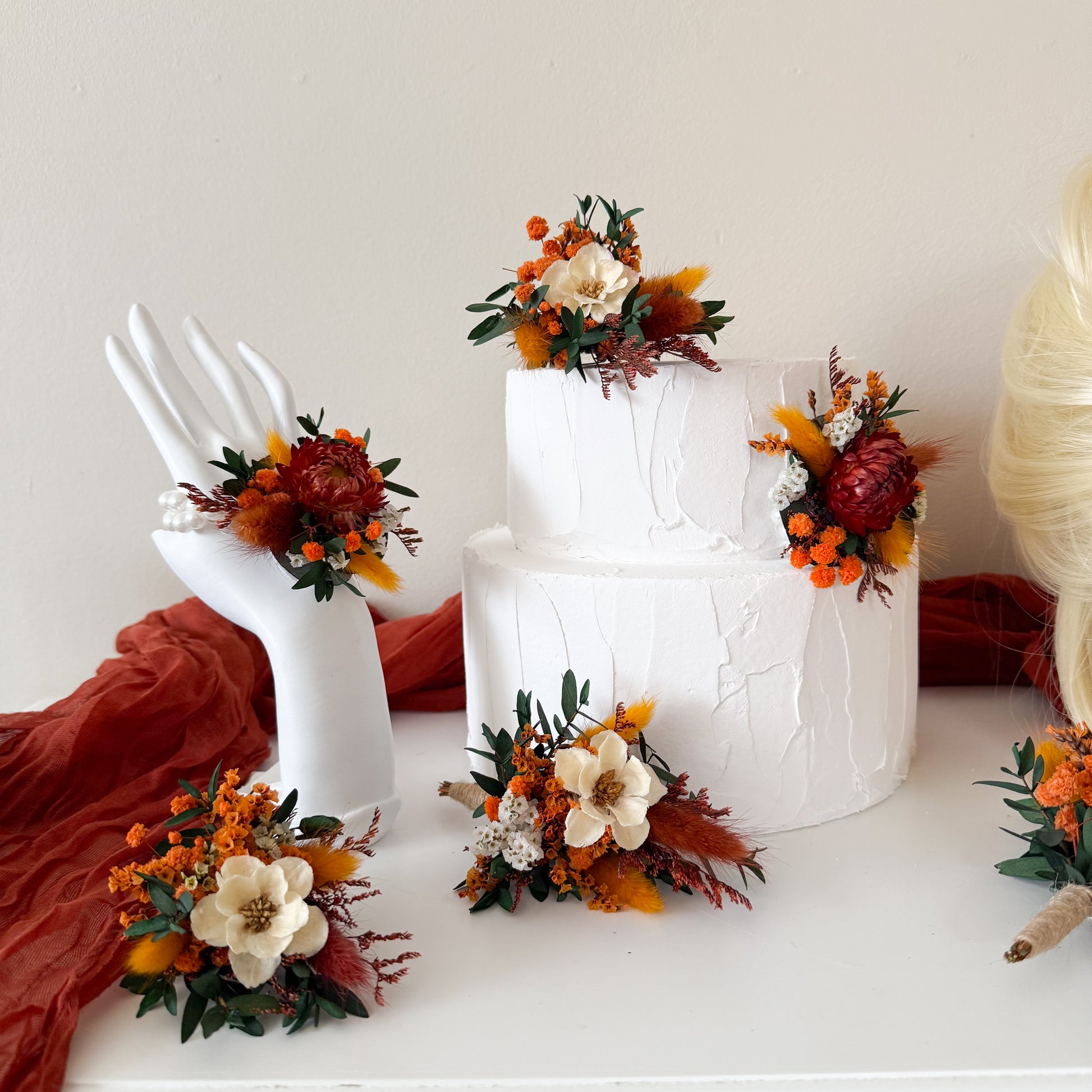 Terracotta and burnt orange dried flower cake topper with ivory blooms and olive foliage
