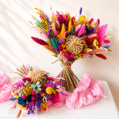 Colourful dried flower bridal bouquet with matching bridesmaid bouquet in vibrant pink, orange, purple and yellow preserved flowers.