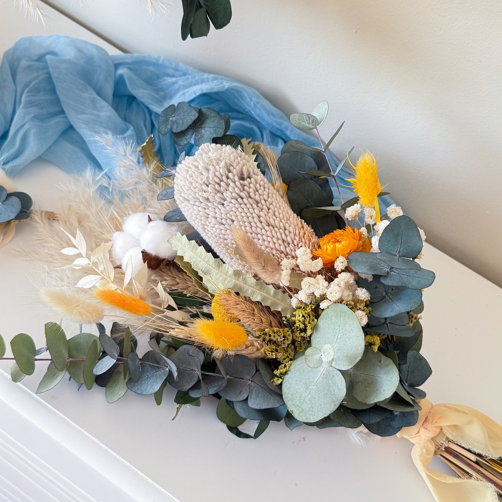 Top view of dried flower wedding bouquet with eucalyptus, pampas grass and yellow floral accents