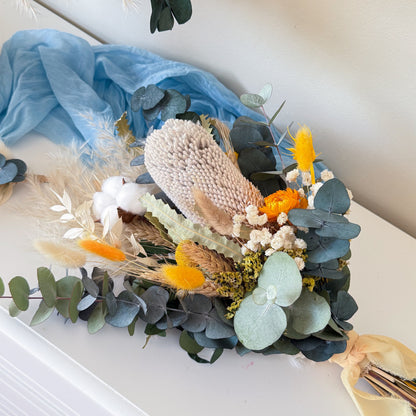 Top view of dried flower wedding bouquet with eucalyptus, pampas grass and yellow floral accents