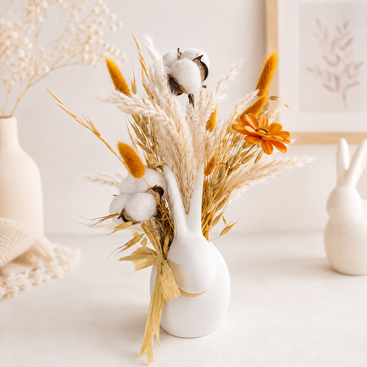 Orange and white dried flower bouquet with cotton and preserved flowers in a neutral home interior