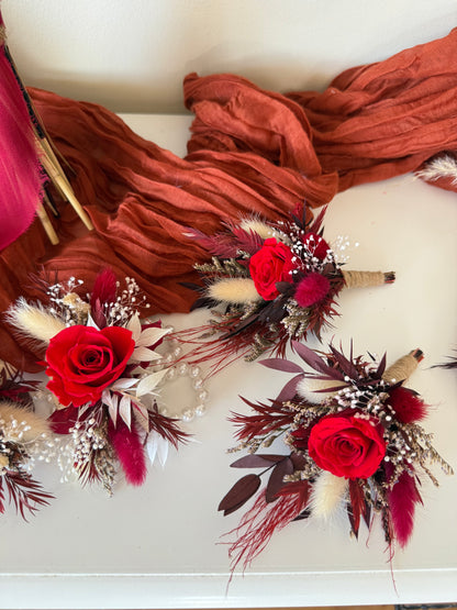 Burgundy boutonnières and corsages made of dried and preserved flowers with roses and pampas accents for wedding party.