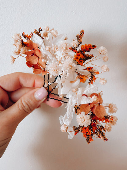 Hand-held dried flower bridal hairpiece in burnt orange and ivory tones, showing preserved flower details for boho and rustic brides