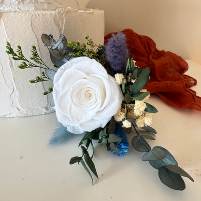 Natural dried and preserved cake topper arrangement featuring soft blue roses, ivory flowers and natural preserved greenery for a romantic boho wedding.