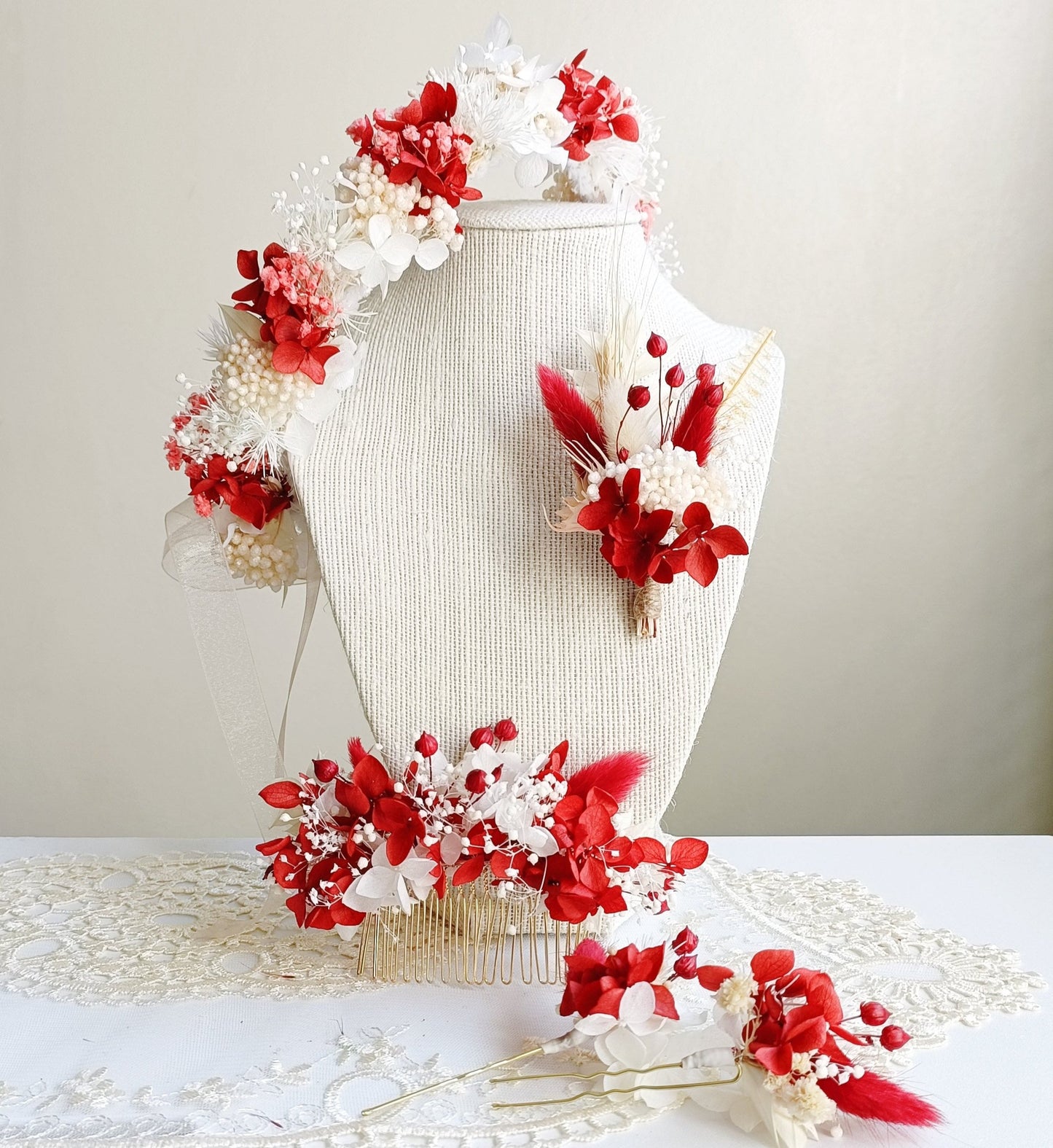  A delicate dried flower crown featuring a bold mix of red and white petals, adorned with tiny pearl accents. The wreath is tied with sheer ribbon, creating an elegant, romantic look for a wedding or special occasion.