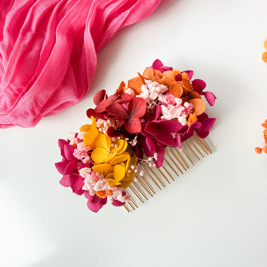 Floral hair comb with pink, orange, and yellow flowers on a white background