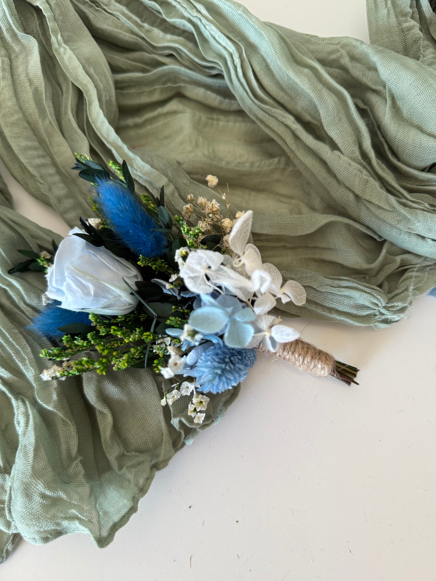 Matching dusty blue boutonniere and bridal bouquet set with sola wood roses and dried flowers for grooms and brides.