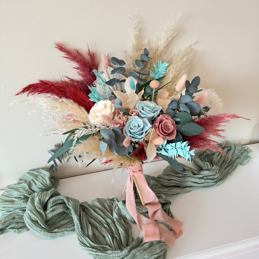 Close-up of dusty blue and blush preserved roses with mint eucalyptus and fluffygrass — Australian boho wedding bouquet