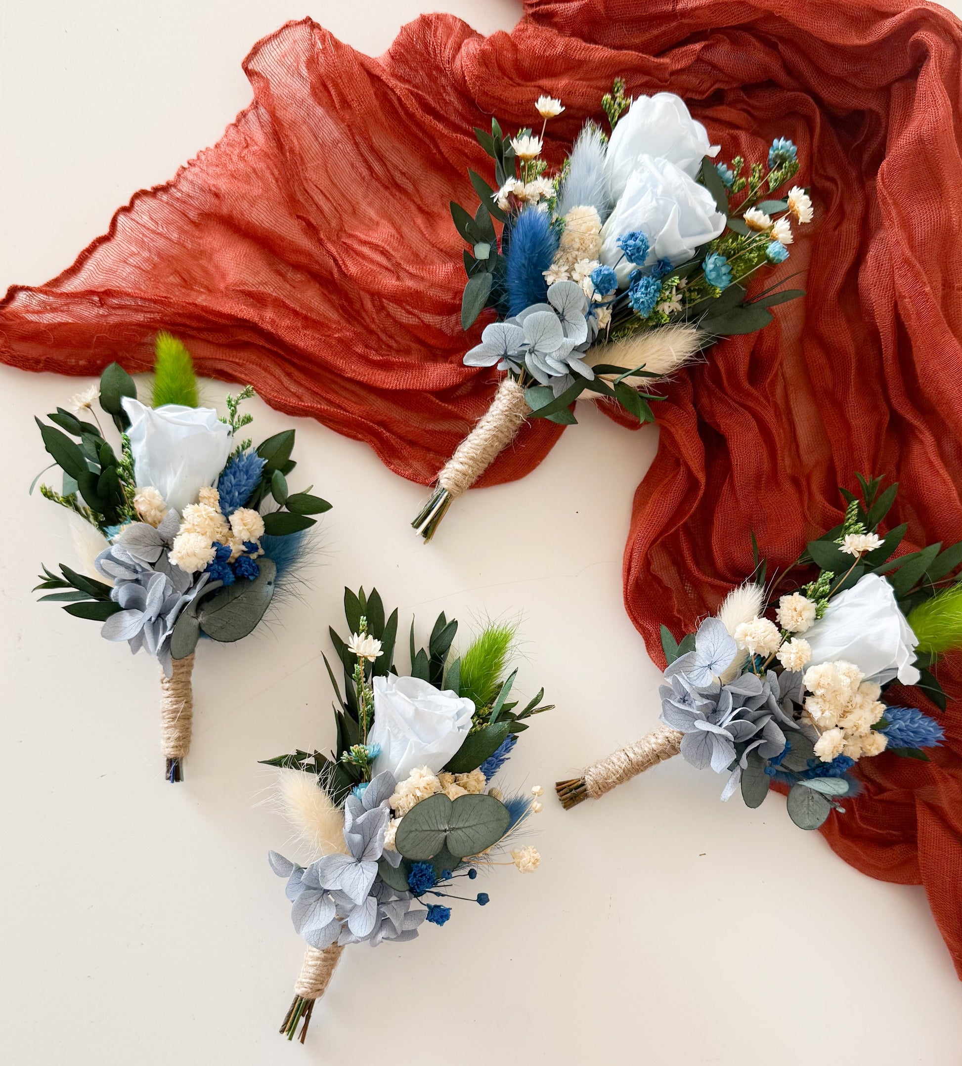 Groom boutonniere featuring dusty blue sola wood flower, preserved greenery, and dried accents — elegant boho accessory for wedding suit.