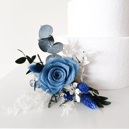 Side view of two-tier cake with elegant floral topper – ideal for blue-themed wedding styling