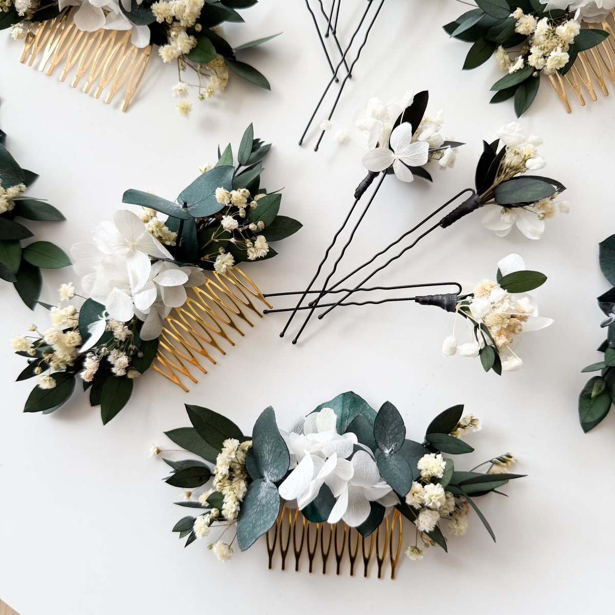 Set of three handmade bridal hair combs with preserved eucalyptus leaves and small white dried flowers.