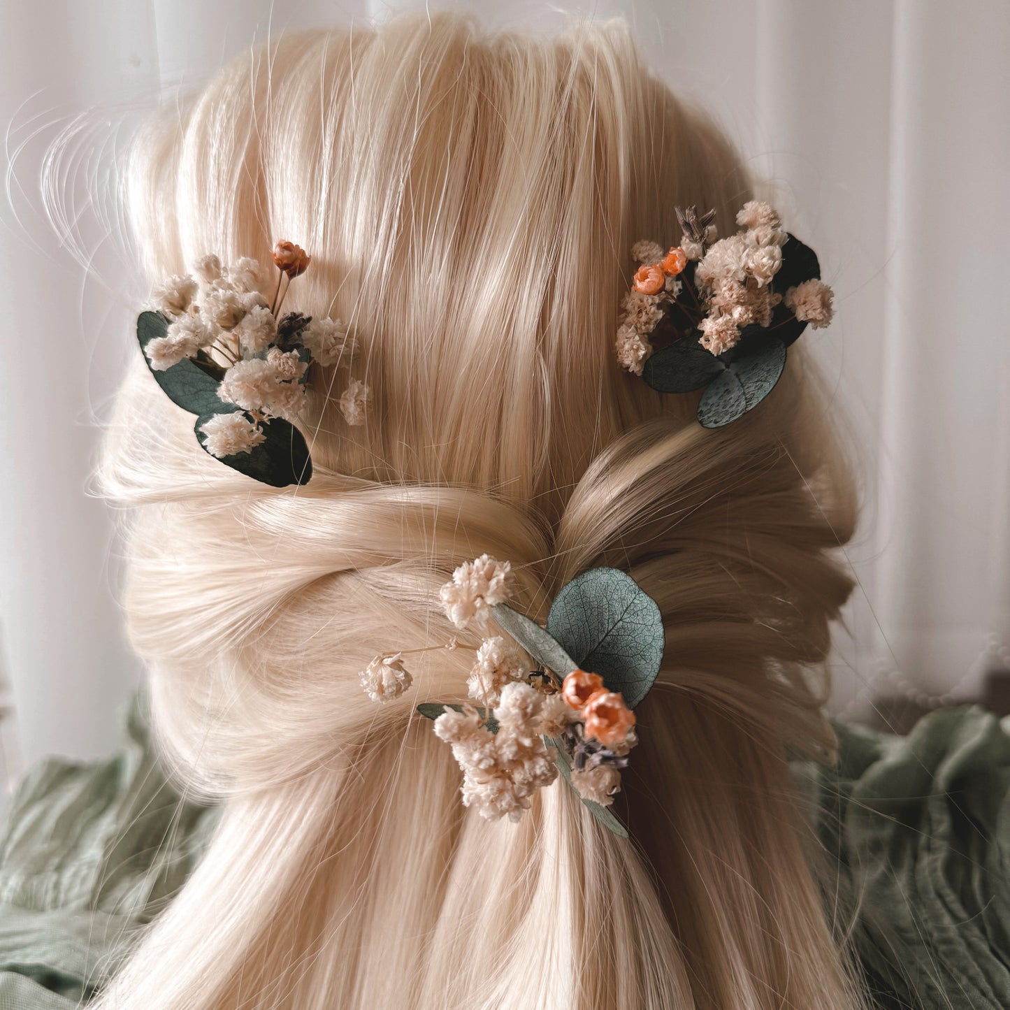 Blonde hair with floral hair clips against a neutral background