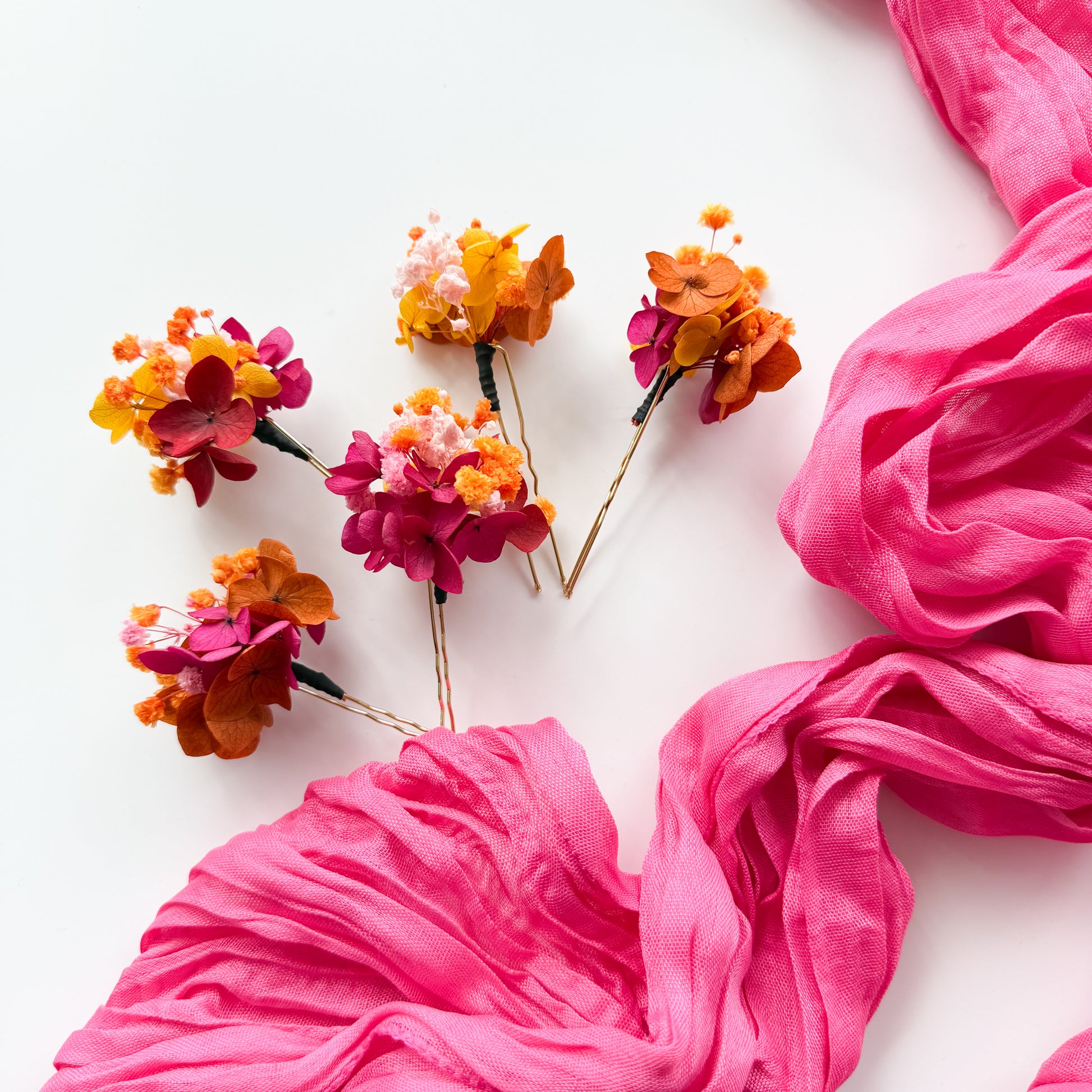 Pink fabric and floral hairpins on a white background