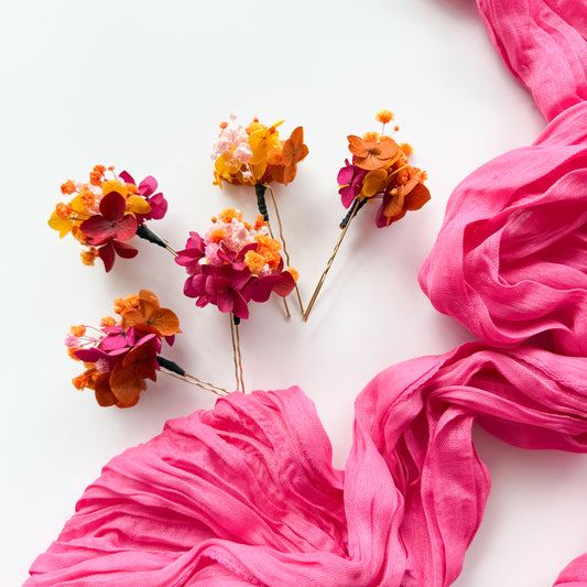 Pink fabric and floral hairpins on a white background