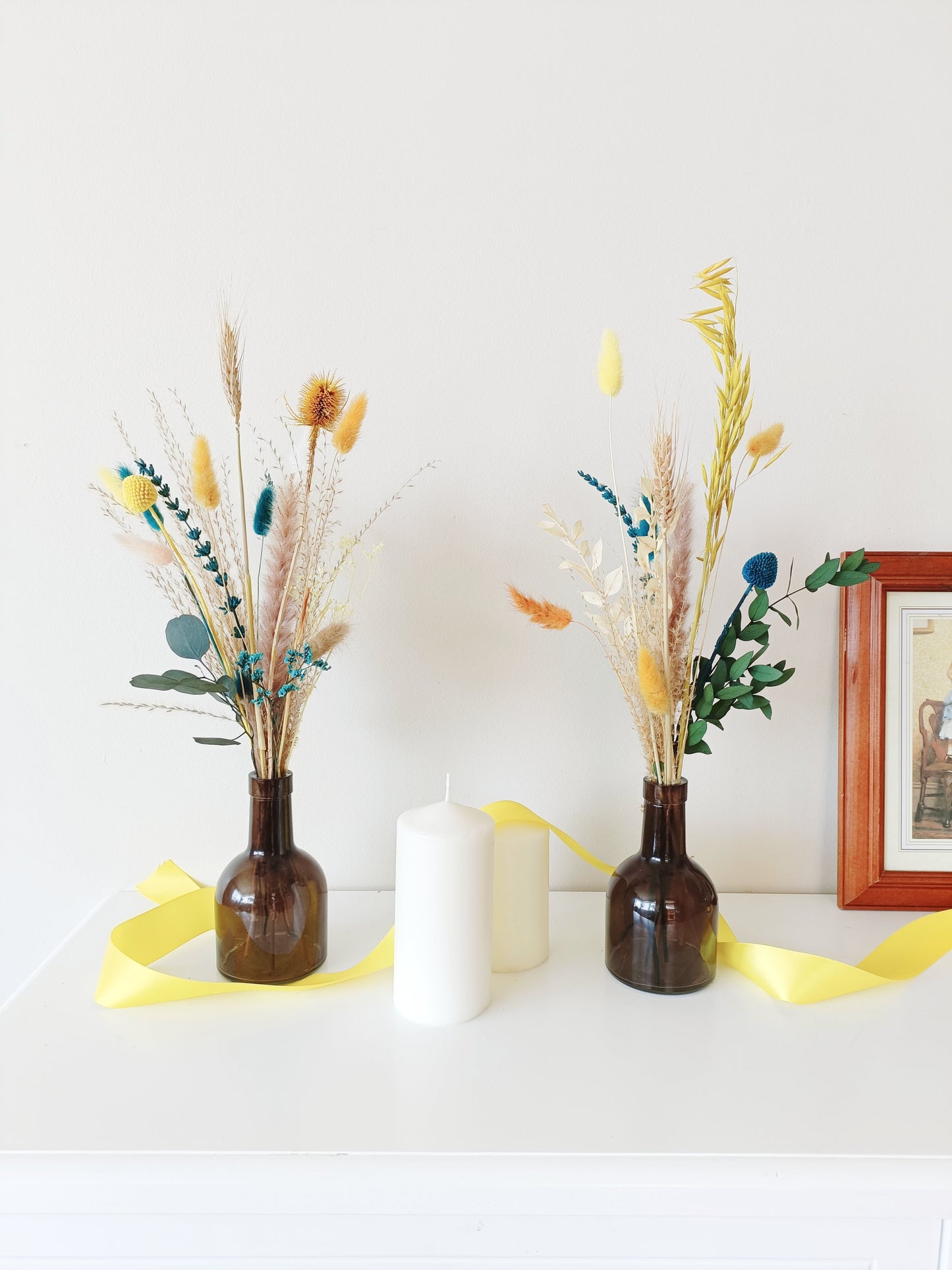 warm-toned dried florals, dried flower styling, floral wedding setup, simple table decor, neutral floral display, dried botanicals arrangement, country-style flower decor, soft pink flower setup, classic boho wedding flowers, vintage-inspired floral decor, delicate flower arrangement, stylish dried flower vase, timeless dried flowers, elegant table styling, wedding reception florals, beige flower display, soft aesthetic floral decor, dried palm leaf bouquet, artistic dried flowers, trendy boho arrangement, 