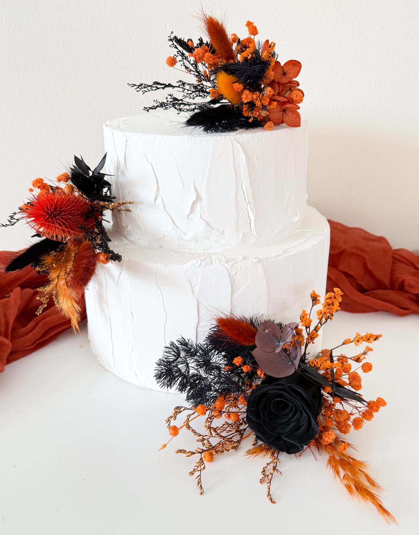 Gothic boho cake decoration made from dried flowers in black and orange tones, handmade in Australia