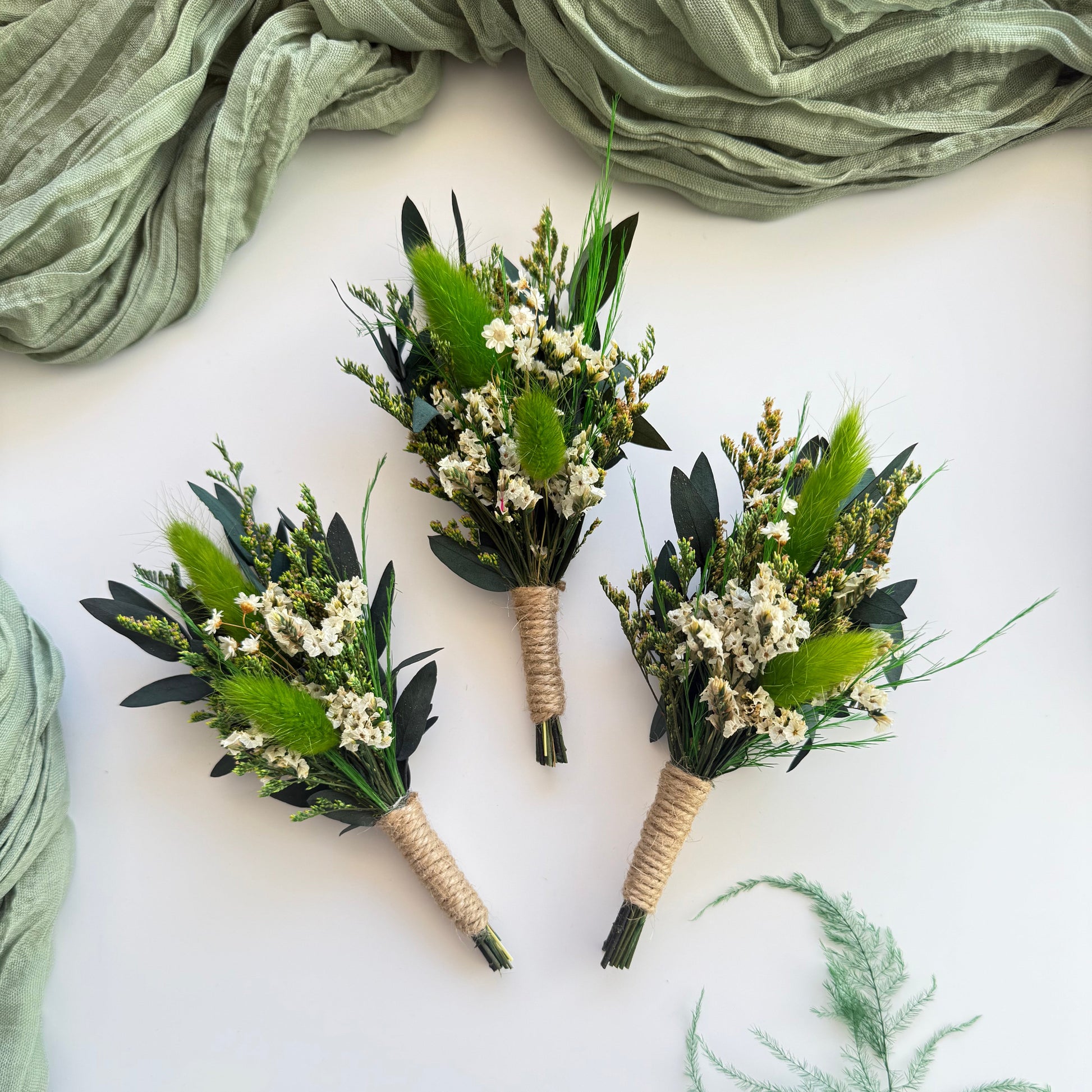 Set of boho greenery boutonnieres with preserved leaves and white florals, rustic wedding accessories