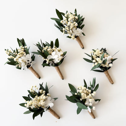 Flat lay display of five dried eucalyptus boutonnieres for groomsmen and groom.