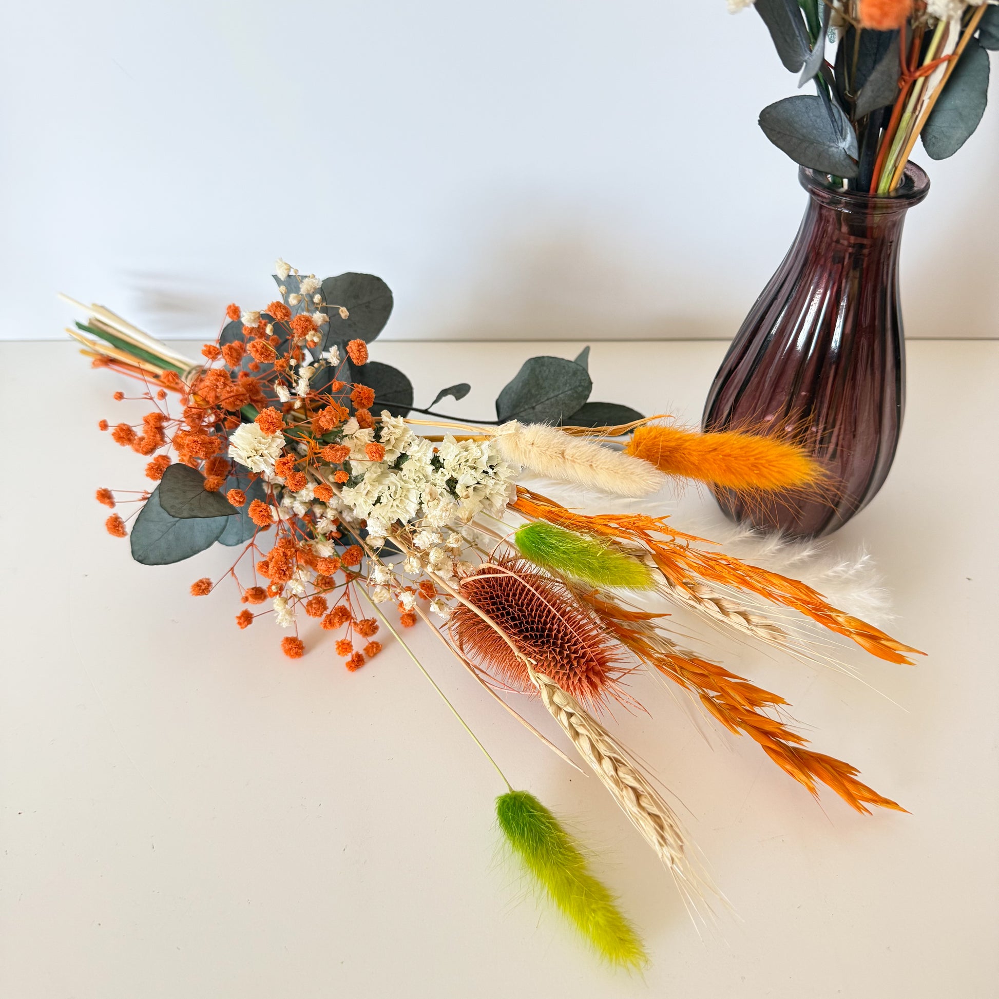 Handmade dried flower arrangement with terracotta bunny tails, ivory accents, and eucalyptus, ideal for boho home or event decor