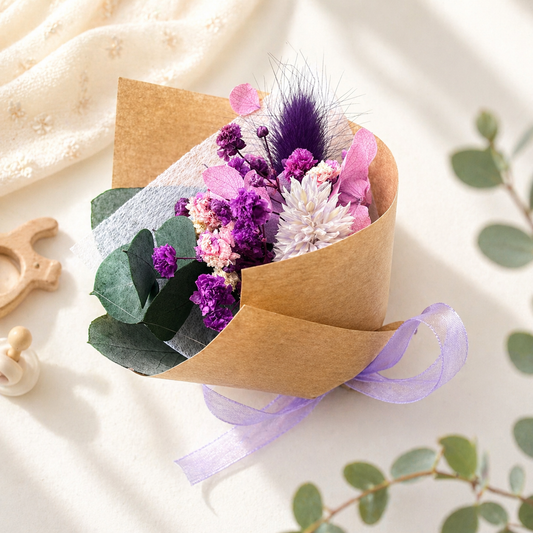 Small bouquet of flowers wrapped in brown paper with a purple ribbon on a light background